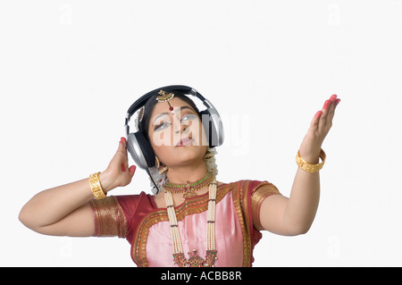 Giovane donna che indossa le cuffie e di eseguire Bharatnatyam Foto Stock