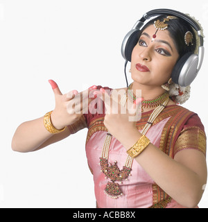 Giovane donna che indossa le cuffie e di eseguire Bharatnatyam Foto Stock