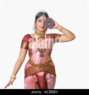 Giovane donna di eseguire Bharatnatyam e in possesso di un CD Foto Stock