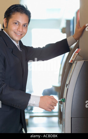 Ritratto di un uomo di affari usando una macchina ATM Foto Stock