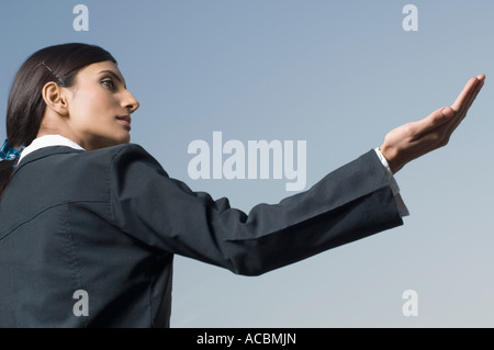 Profilo laterale di una imprenditrice tenendo il palmo fuori Foto Stock