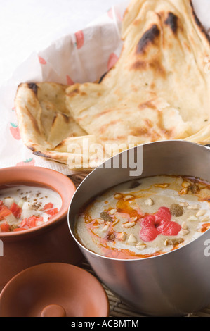 Close-up di pane indiano servito con curry e latticini Foto Stock