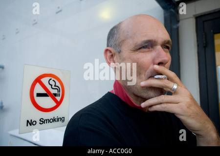 Fumo di uomo di fronte non fumatori segno Foto Stock