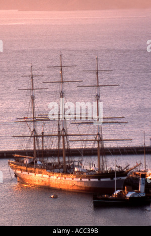 Tre alberi a vela in porto al tramonto Foto Stock