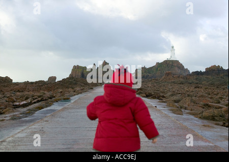 Bambino piccolo che cammina verso Corbiere Lighthouse St Brelade's Jersey Channel Islands Foto Stock