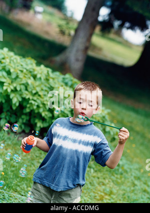 Un ragazzo soffiando bolle di sapone. Foto Stock