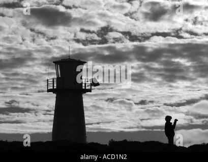 Persona tenendo fotografia al tramonto nella parte anteriore del west cape lighthouse, parco nazionale di innes, Sud Australia, Foto Stock