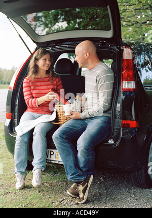Un giovane avente picnic in un'auto. Foto Stock