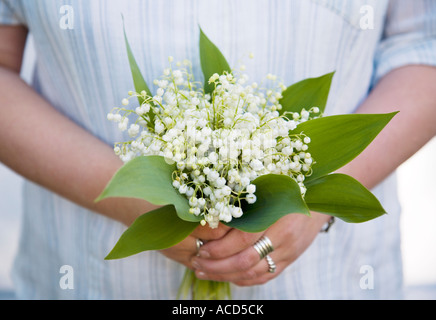 Donna con un bouquet di mughetti. Foto Stock