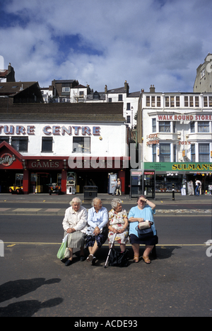 Inglese cittadina balneare di Scarborough con i vacanzieri seduti su un banco di lavoro Foto Stock