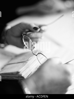 Mani femminili in possesso di un paio di occhiali close-up BW. Foto Stock