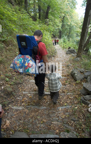 Padre e figlio a piedi nei boschi di castagno di Savogno, Sondrio, Italia Foto Stock