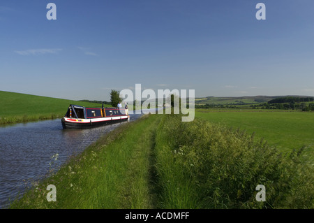 Narrowboat viaggiare sul pacifico, Scenic, tratto rurale di Leeds Liverpool canal - North Yorkshire, Inghilterra, Regno Unito. Foto Stock