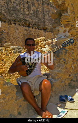 L'uomo gioca il Bouzouki presso la fortezza di Frangokastello Creta Foto Stock