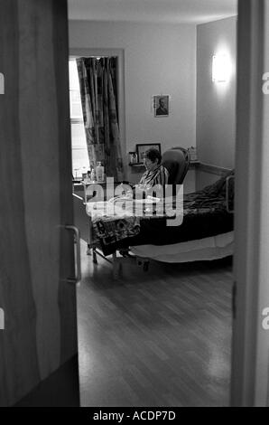 Una donna anziana in una casa di cura. Foto Stock