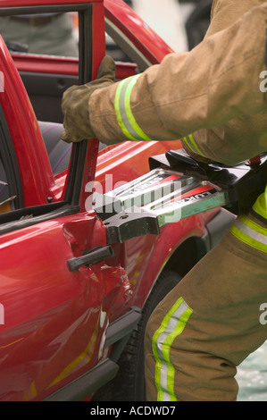 Fireman utilizzando le ganasce della vita per accedere a un incidente di macchina vittima Foto Stock