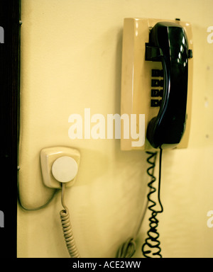 Un telefono con un telefono nero ricevitore appeso alla parete. Foto Stock