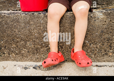 Chiusura del giovane ragazzo per le gambe sui passi Foto Stock