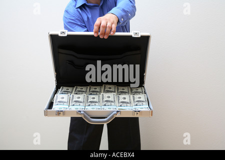 Uomo con valigetta aperta piena di denaro Foto Stock