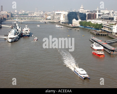 Londra Semi aerial del Fiume Tamigi acqua bus ponti HMS Belfast e visitando sforzarsi a fianco dello skyline della città Foto Stock