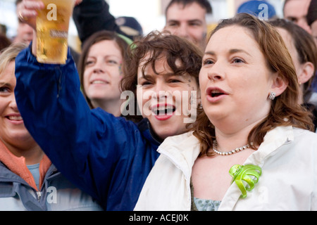 Le donne gridavano e tenendo la birra in vetro outdoor music festival in Irlanda Foto Stock