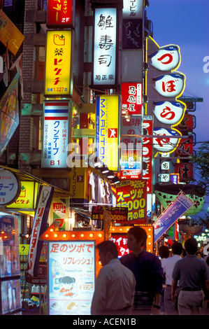 Le insegne al neon illuminano il famoso ristorante e quartiere dei divertimenti di Dotonbori di Osaka di notte, attirando folle di vita notturna, in Giappone. Foto Stock