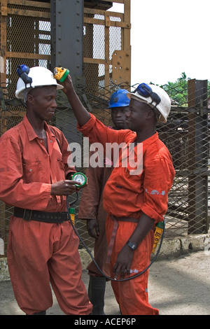 Gold Miner facendo una salute e controllo di sicurezza tra i colleghi le attrezzature minerarie prima del prossimo turno della metropolitana, Ghana Foto Stock