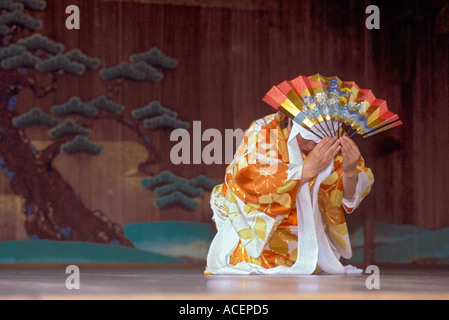 Interprete nel tradizionale costume Noh mantenendo la ventola esegue una mossa durante un gioco Kyogen Foto Stock