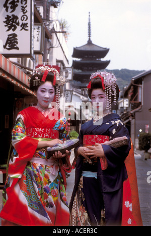 Due maiko o geisha in formazione passeggiando lungo una stradina in Kyoto Foto Stock