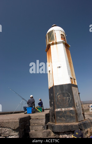 Il Galles Glamorgan Porthcawl sea wall ghisa faro e due pescatori Foto Stock