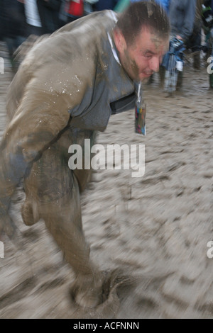 Un festival goer coperto di fango al Glastonbury festival di musica 2007. Foto Stock