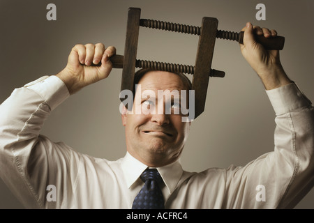 Uomo con la testa nella morsa Foto Stock