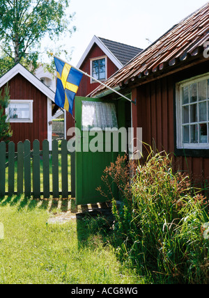 Cottage di rosso con la bandiera svedese nell arcipelago di Stoccolma Svezia Sandhamn. Foto Stock