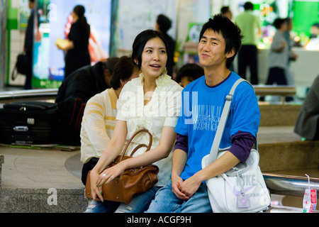 Giovane coppia coreana Seduta Seduta e di parlare insieme a un Mall Seoul COREA DEL SUD Foto Stock