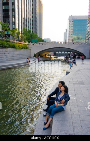 La mezza età matura seduti insieme accanto a Cheonggyecheon o flusso Cheonggye Seoul COREA DEL SUD Foto Stock