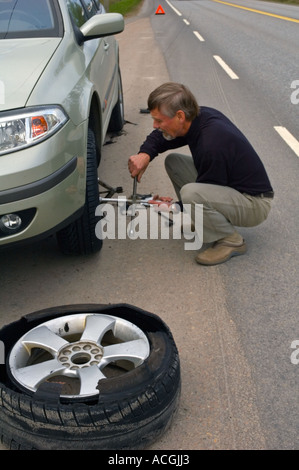 L'uomo modifica di un nuovo pneumatico al posto di un burst fuori uno in Finlandia UE Foto Stock