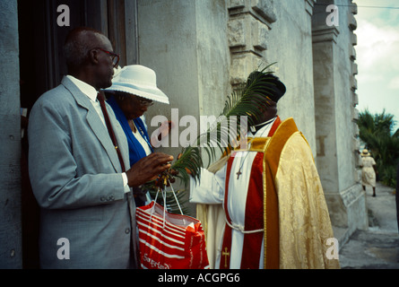 St Johns Antigua Cattedrale sacerdote e giovane con l uomo azienda filiale di Palm dopo la Domenica delle Palme Service Foto Stock