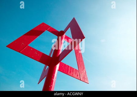 Un rosso brillante marcatore sulla spiaggia situato sul mare di un muro di difesa di pausa. La marea è venuta con onde rilassante e cielo blu Foto Stock