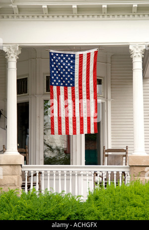 Portico in stile vittoriano, bandiera americana & Sedia a dondolo su Main Street USA. Foto Stock