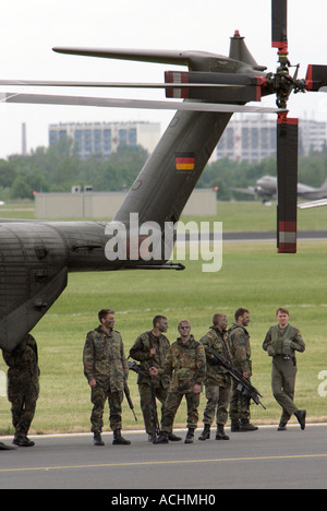 Tedesco soldato armato accanto a un Sikorsky CH-53 G elicottero da trasporto dell'esercito tedesco durante ILA 2006 a Berlino Foto Stock