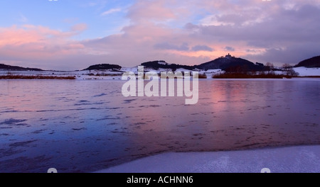 Il castello di Wachsen in Turingia dietro un lago con riflessi del tramonto Foto Stock