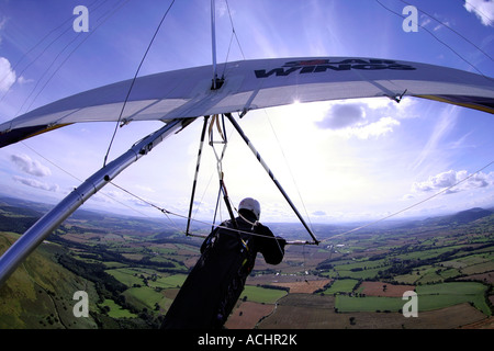 In volo il colpo di un deltaplano volare verso il sole nel lungo Mynd Shropshire REGNO UNITO Foto Stock