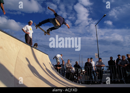 Europa Norvegia Oslo Skateboarders eseguire salti su rampa lungo Oslos vicino lungomare di Aker Brygge durante la gara Foto Stock