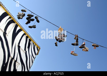 Una fila di scarpe trainer gettato sopra un cavo telefonico in funky Sydney Street Brighton come parte di una mania adolescente in tutta la Gran Bretagna. Foto Stock