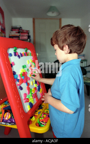 Bambino autistico giocando con scritte colorate (sintetico fonica), Middlesex, Inghilterra. Foto Stock