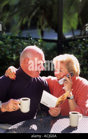 Una sana coppia in pensione nel suo 70s di caffè e parlare con la famiglia Foto Stock