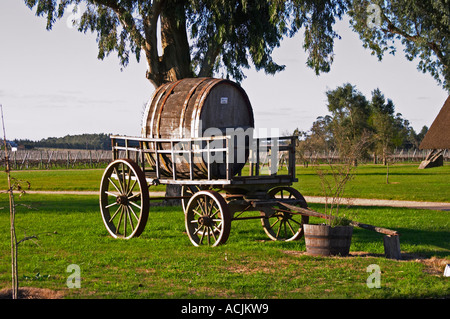 Un vecchio carro trainato da cavalli carrello con un vecchio Barile di legno nel giardino di fronte alla vigna. Bodega Juanico Familia Deicas Cantina Juanico, Canelones, Uruguay Sud America Foto Stock