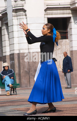 Plaza de Cagancha Square, un giovane uomo e donna ballare Flamenco e tango su una piazza della città, vestito di mantello blu top nero, bianco pantaloni e camicia blu e cappello nero. Donna battendo le mani e due curiosi guardando. Montevideo, Uruguay Sud America Foto Stock