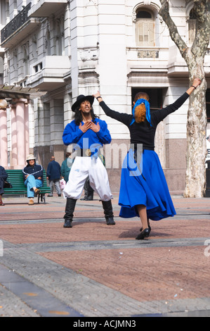 Plaza de Cagancha Square, un giovane uomo e donna ballare Flamenco e tango su una piazza della città, vestito di mantello blu top nero, bianco pantaloni e camicia blu e cappello nero. L'uomo gesticolando la passione e l amore e la donna tenendo fuori le sue braccia in benvenuto. Montevideo, Uruguay Sud America Foto Stock