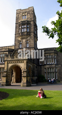 Donna sat sull'erba al di fuori del Cliffe Castle Museum e la Galleria Keighley West Yorkshire Foto Stock